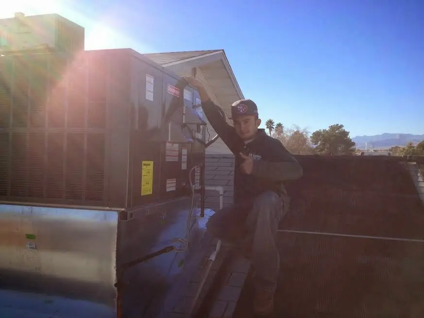 HVAC technician performing HVAC Inspection on a rooftop unit in Cambridge